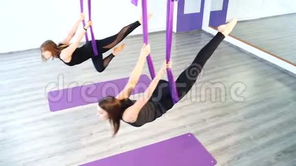 一群年轻女性在工作室用吊床做空中瑜伽视频的预览图