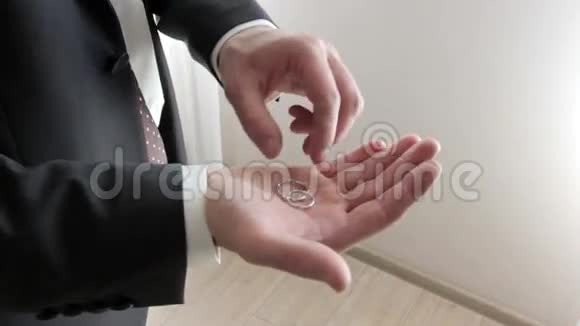 穿着西装拿着两枚结婚戒指的男人视频的预览图