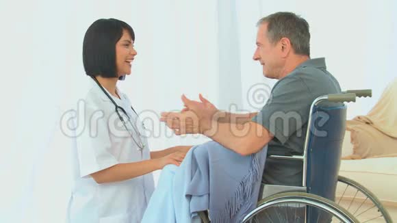 一个坐在轮椅上和护士说话的男人视频的预览图