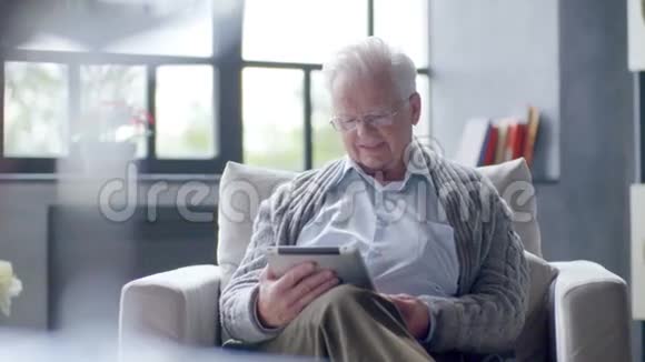 老人在家里使用平板电脑视频的预览图