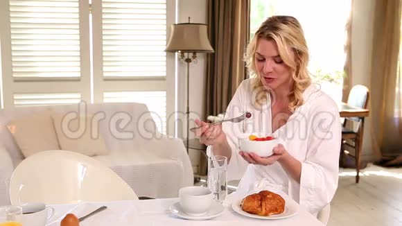 穿着浴袍的女人在吃早餐视频的预览图