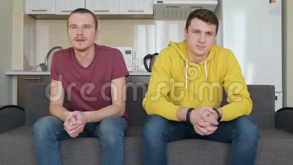两个人坐在沙发上看足球赛视频的预览图