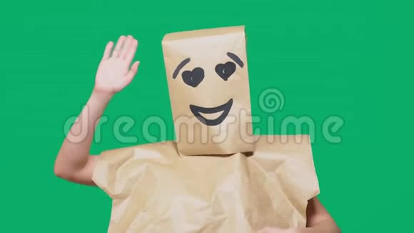 情感概念手势一个头上戴着纸袋的人画着表情符号微笑快乐爱的眼睛视频的预览图