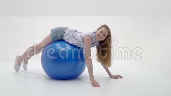 小女孩在一个大球上做健身运动视频的预览图