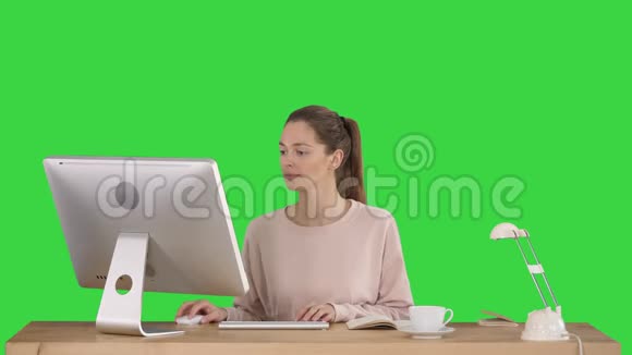 美女在电脑上工作屏幕是绿色的色度键视频的预览图