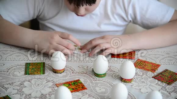 男孩把贴纸贴在复活节彩蛋上视频的预览图