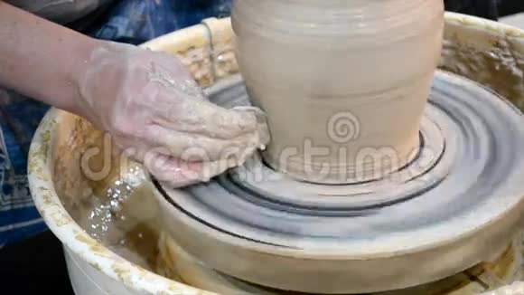 人们用手把壁壶敲成圆形用粘土雕刻视频的预览图