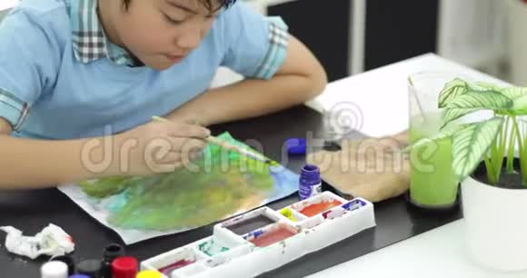 快乐的亚洲可爱的孩子用笑脸在纸上画水色视频的预览图