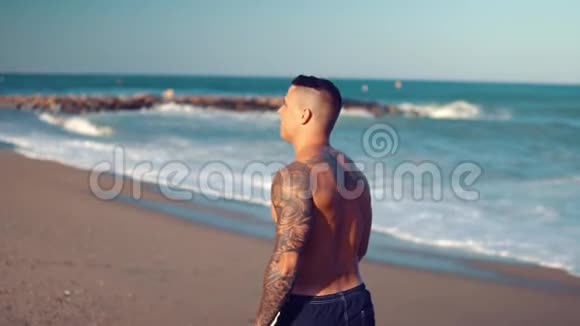 纹身健美性感男教练在海滩视频的预览图