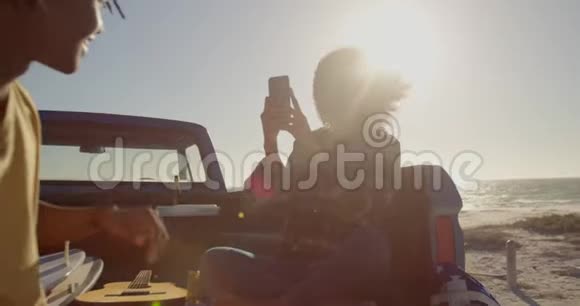 女人在沙滩上用手机拍照视频的预览图