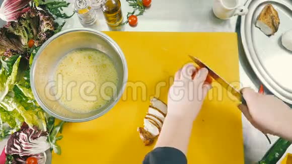 厨师的双手在切割板上切下一个新鲜的番茄视频的预览图