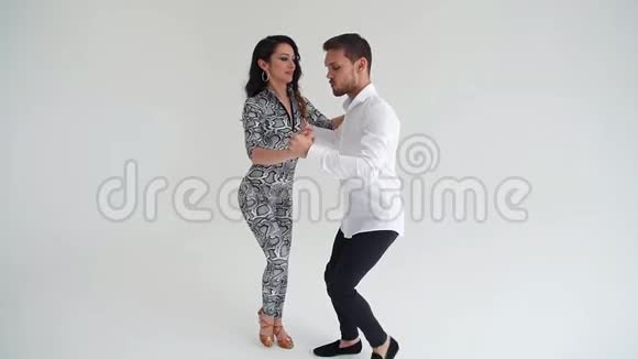 爱人际关系和社交舞蹈的概念年轻漂亮的一对在白色背景下跳性感舞蹈的夫妇视频的预览图
