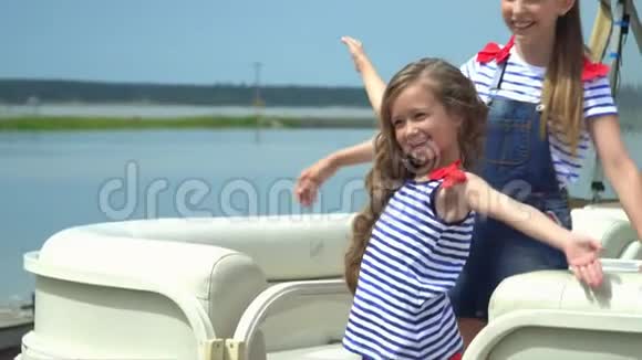 那个动作慢下来的小美丽的女孩在水上的小船附近转过身来视频的预览图