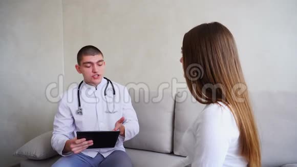 女孩来看医生医生开了药男人和女人坐在医疗办公室的沙发背景灰色的墙壁视频的预览图