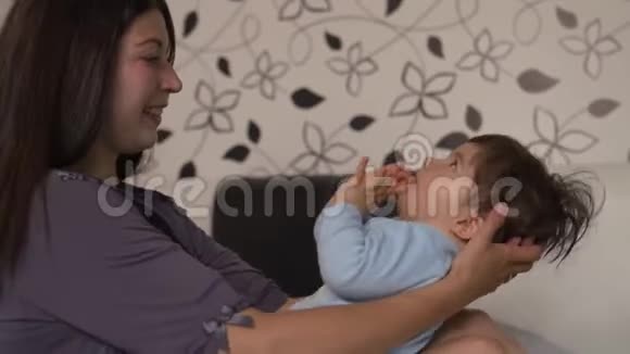 怀孕的母亲和她的小儿子躺在卧室的床上玩耍玩得很开心亚裔混血儿男孩视频的预览图