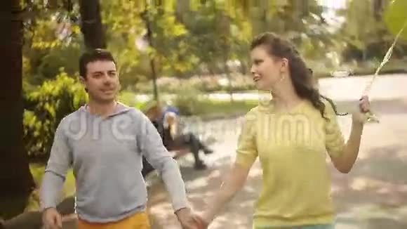 一对拿着气球在公园散步的夫妇视频的预览图