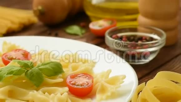 新鲜煮熟的法法勒配切好的西红柿和罗勒视频的预览图