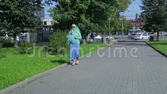 公园里一个戴着浅色围巾的年轻穆斯林妇女正在喝咖啡视频的预览图