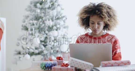 年轻女子在圣诞节用笔记本电脑视频的预览图