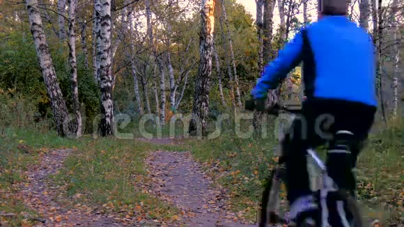 骑自行车的人在公园里沿着一条小路骑车视频的预览图