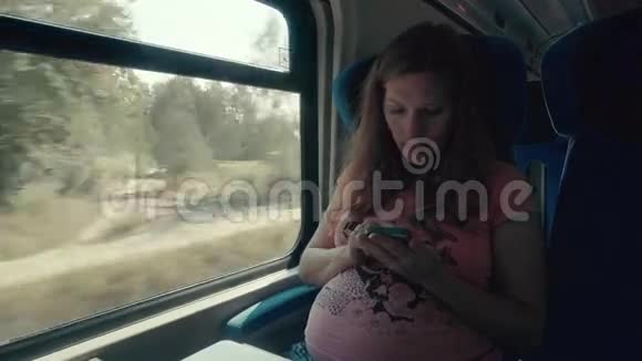 怀孕妇女在火车上用智能手机工作视频的预览图