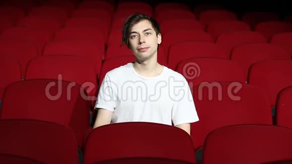 一个人独自坐在空荡荡的电影院或剧院里视频的预览图