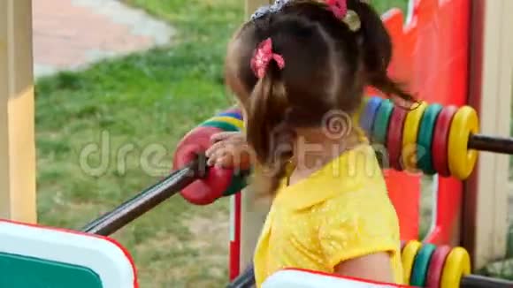 微笑的小女孩在公园里玩她喜欢旋转木马视频的预览图