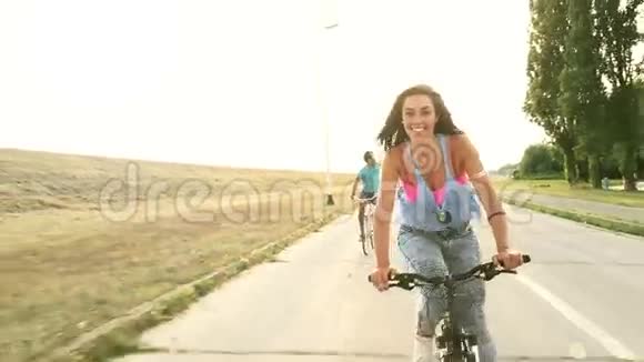 美丽的女人在和朋友骑自行车的时候送吻视频的预览图