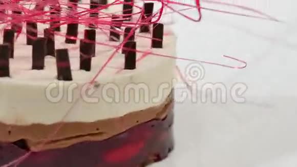 奶油蛋糕盘子上有三层奶油蛋糕三层巧克力面包屑和巧克力装饰视频的预览图
