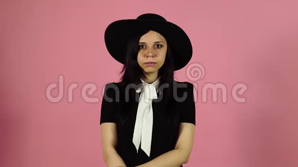穿黑色连衣裙和帽子的年轻女性视频的预览图