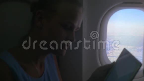 从飞机窗口取出平板电脑的女人视频的预览图