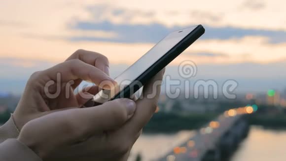 日落后城市里使用智能手机的女人视频的预览图