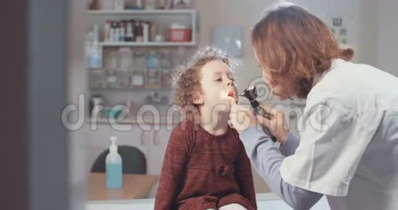 女医生检查一个可爱小女孩的喉咙视频的预览图