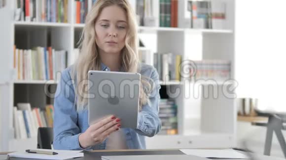 年轻女子在平板电脑上浏览互联网视频的预览图