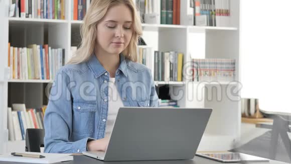 美丽的年轻女子在笔记本电脑上工作视频的预览图