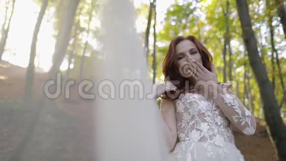 穿婚纱的新娘在森林公园戴面纱很开心恋爱中的女人视频的预览图