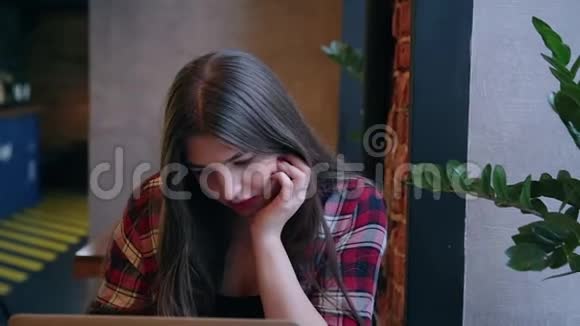 一位漂亮的女商人正坐在一张桌子旁在咖啡馆里拿着笔记本电脑工作视频的预览图