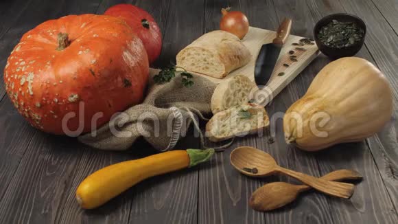 万圣节蔬菜的组成木制桌子背景装饰橙色和黄色南瓜洋葱种子南瓜视频的预览图