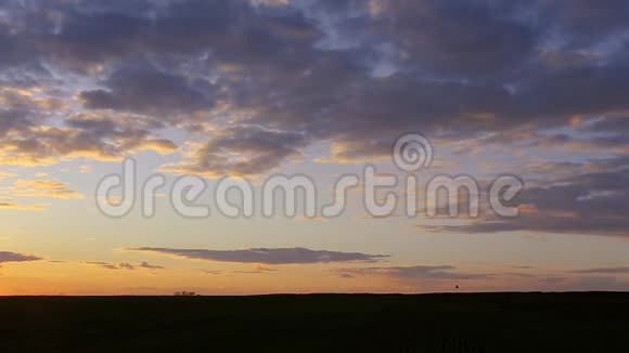 自然日落日出在田野或草地上明亮的戏剧天空在地面上风景下的乡村景观视频的预览图