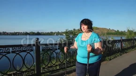 在一个阳光明媚的夏日早晨一个女人用棍子穿过公园视频的预览图