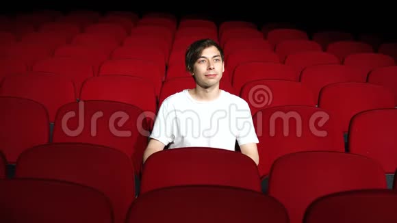一个人独自坐在空荡荡的电影院或剧院里看表演或电影视频的预览图