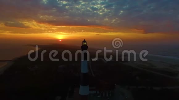 海岸日出有一个灯塔就像4K的无人机看到的那样视频的预览图