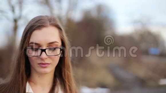 戴眼镜的漂亮女孩对着镜头微笑视频的预览图