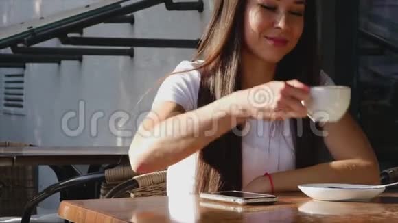 年轻有魅力的女人在街上喝咖啡视频的预览图