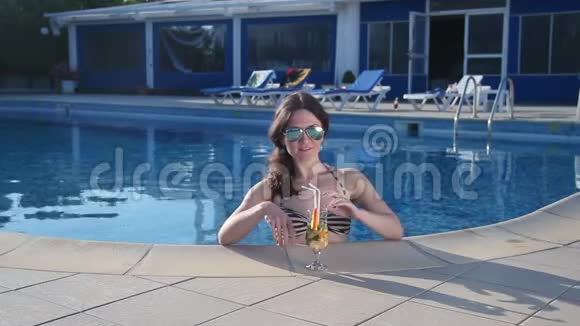 美丽的女士穿着比基尼喝鸡尾酒享受炎热的夏天视频的预览图