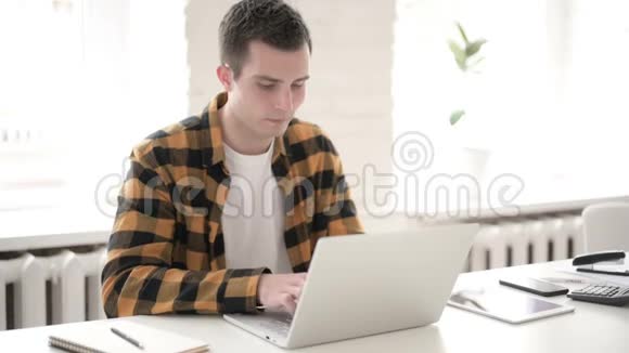 休闲青年在笔记本电脑上工作视频的预览图