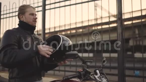 带着头盔和定制摩托车的年轻有魅力男子摩托车视频的预览图