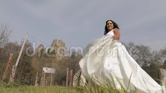穿着婚纱和面纱的美丽可爱的新娘慢动作视频的预览图
