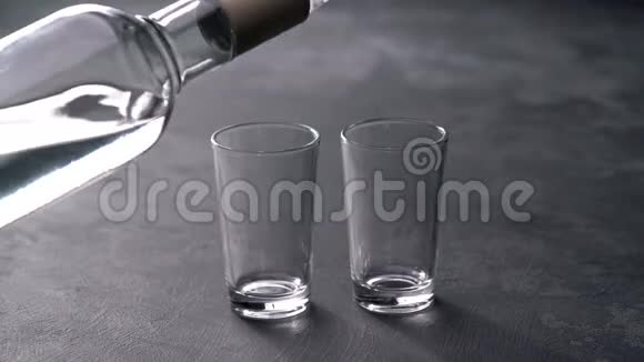 伏特加从一个瓶子倒进一个黑色背景的杯子里视频的预览图