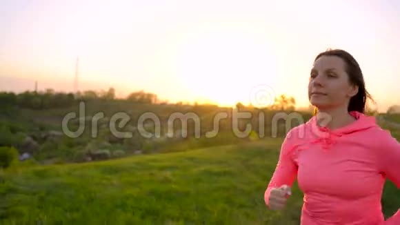 日落时分女人在户外跑慢动作视频的预览图